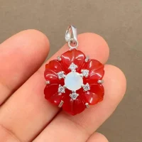 silver pendant with carved flower red onyx gemstone with rainbow moonstone and cubic zirconia displayed on hand