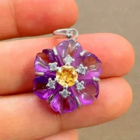 silver pendant with carved flower amethyst gemstone with citrine and cubic zirconia displayed on hand