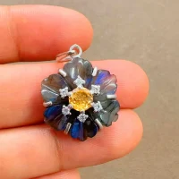 silver pendant with carved flower labradorite gemstone with citrine and cubic zirconia displayed on hand