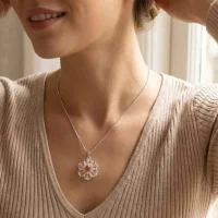 model wearing silver pendant with carved flower crystal gemstone with carnelian and cubic zirconia