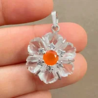 silver pendant with carved flower crystal gemstone with carnelian and cubic zirconia displayed on hand